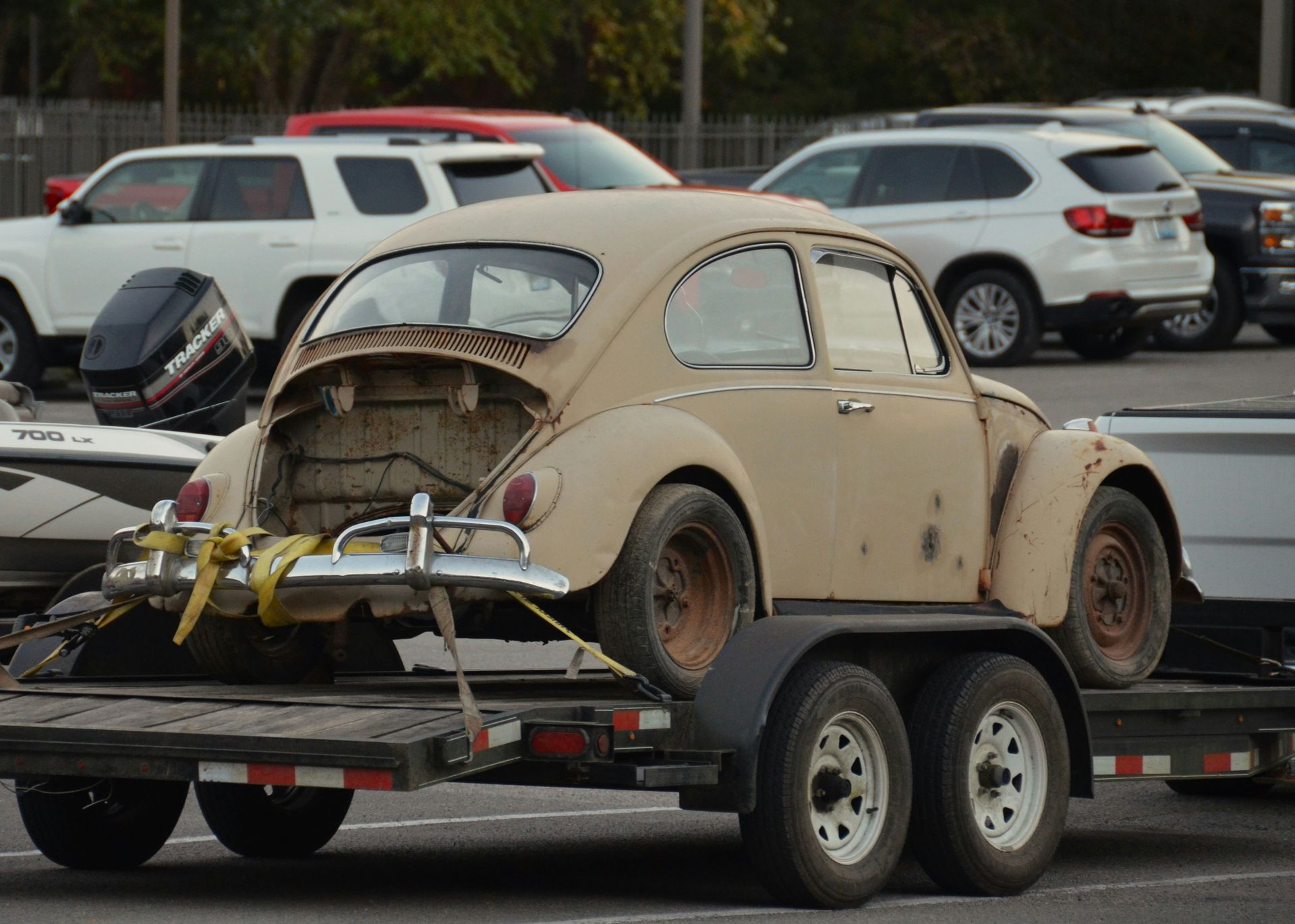 an old car on a trailer in a parking lot